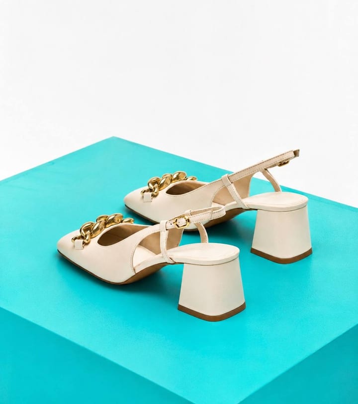 Cream slingback block-heel mules with a gold chain trim